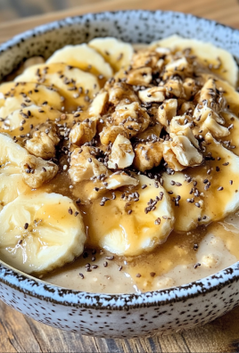 Bowl of oatmeal topped with banana slices, chopped walnuts, chia seeds, and syrup.